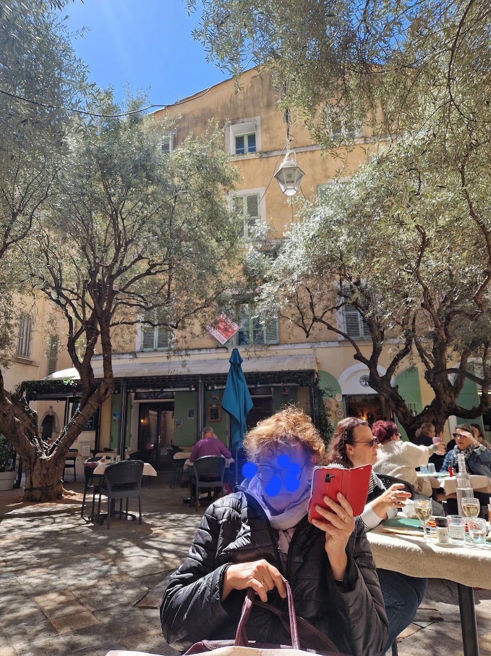 La devanture du restaurant et sa terrasse ombragée sur la place